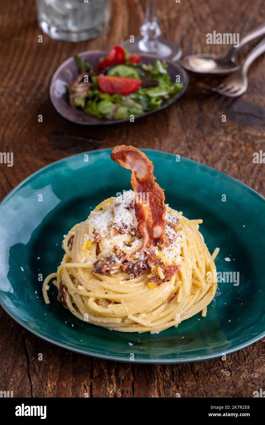 spaghetti alla carbonara con insalata su legno Foto Stock