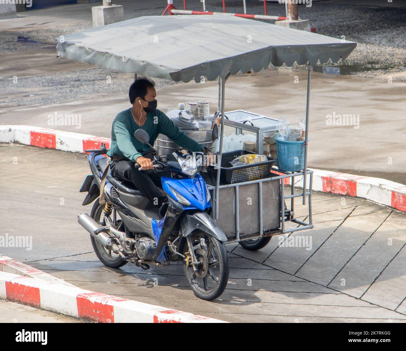 SAMUT PRAKAN, THAILANDIA, 23 2022 SETTEMBRE, il venditore guida una motocicletta a tre ruote con carrello Foto Stock
