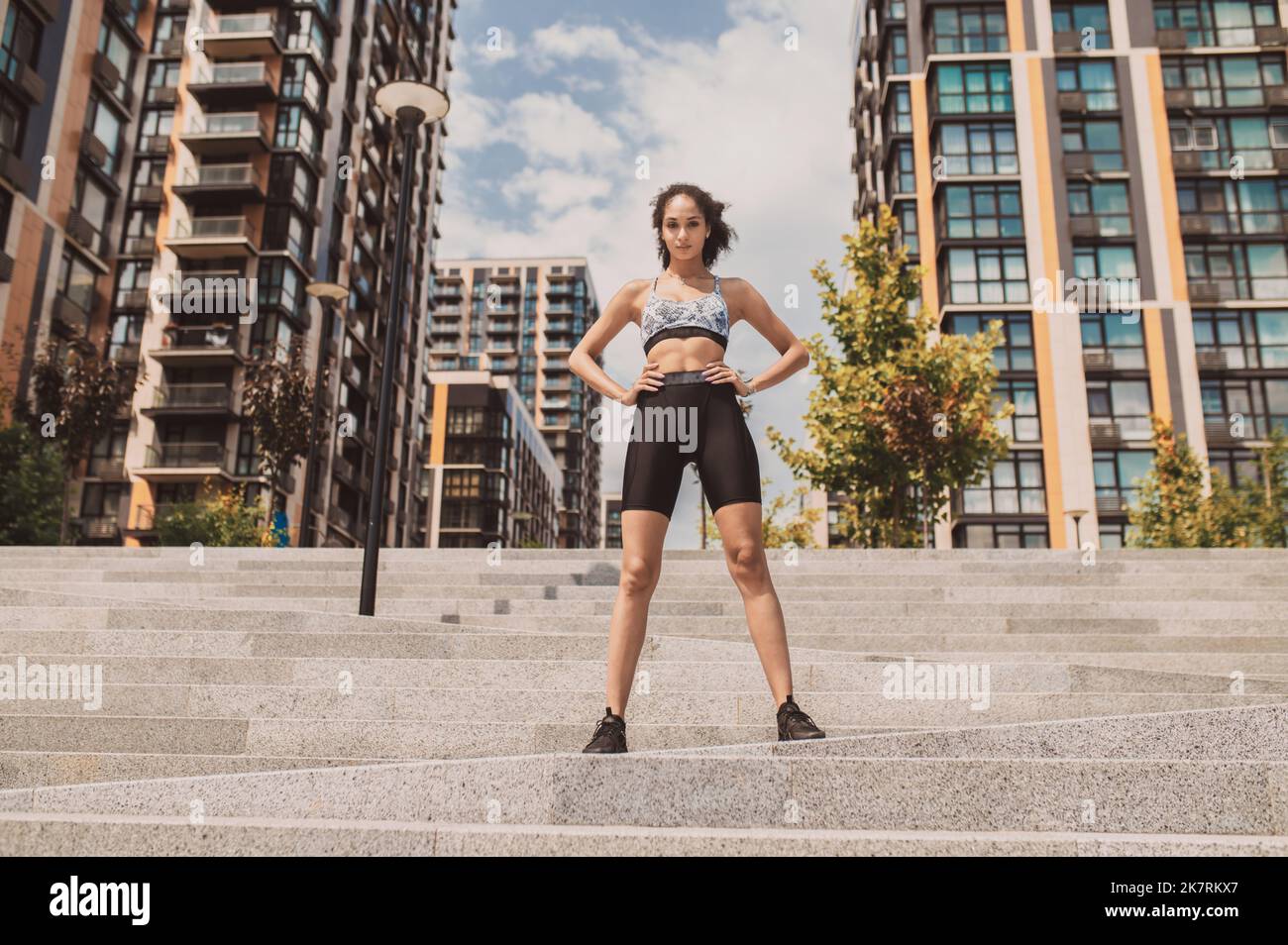 Ragazza sportiva ben costruita in abbigliamento sportivo che guarda sicuro Foto Stock