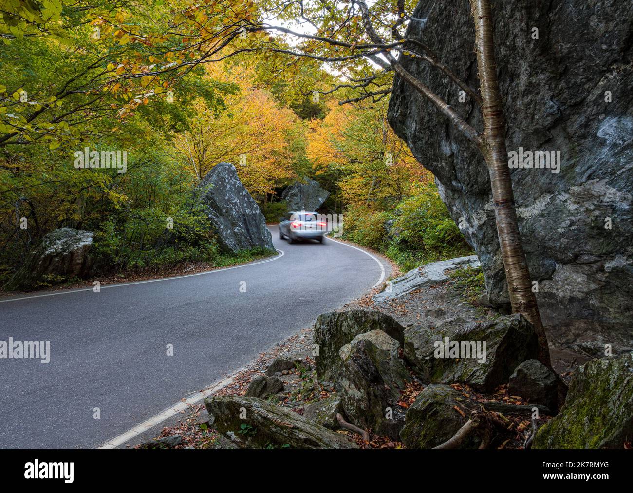 In autunno, l'auto fa una curva stretta tra massi nella tacca Smugglers Foto Stock