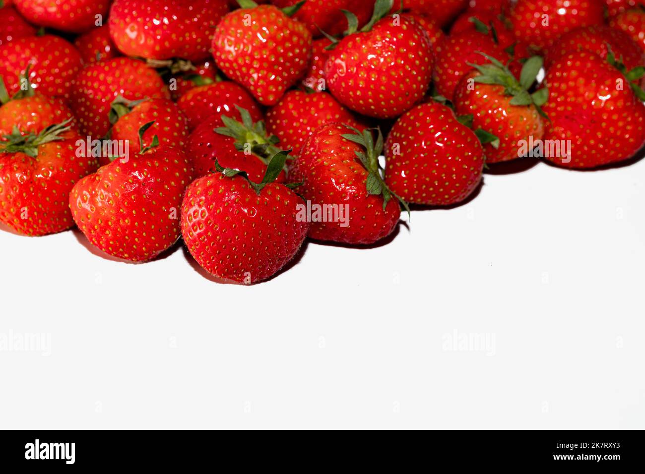 Fresche fragole rosse su fondo bianco Foto Stock