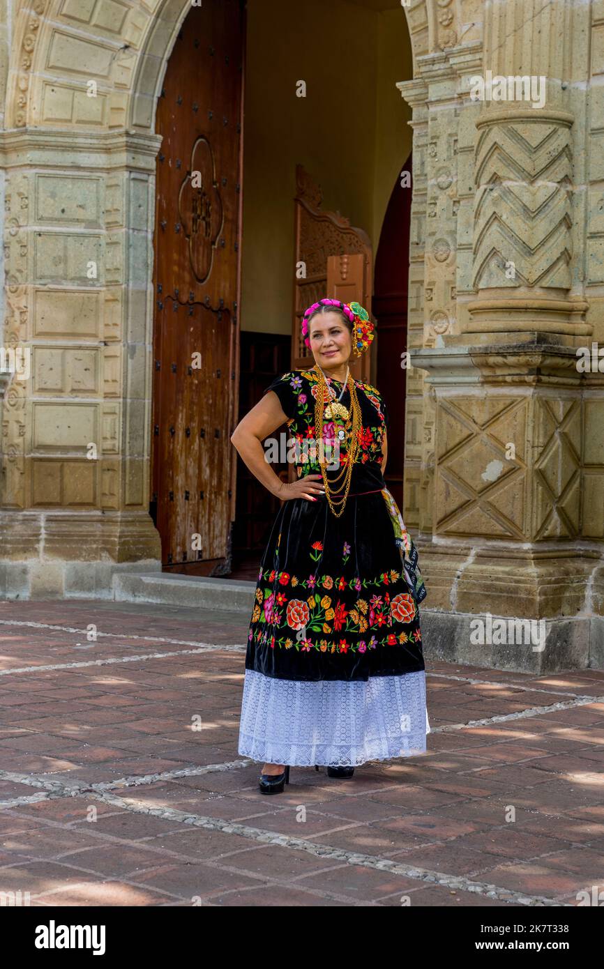 Una donna locale in abito tradizionale si sta posando per le foto in una strada del Barrio de Jalatlaco, a Oaxaca City, Messico. Foto Stock