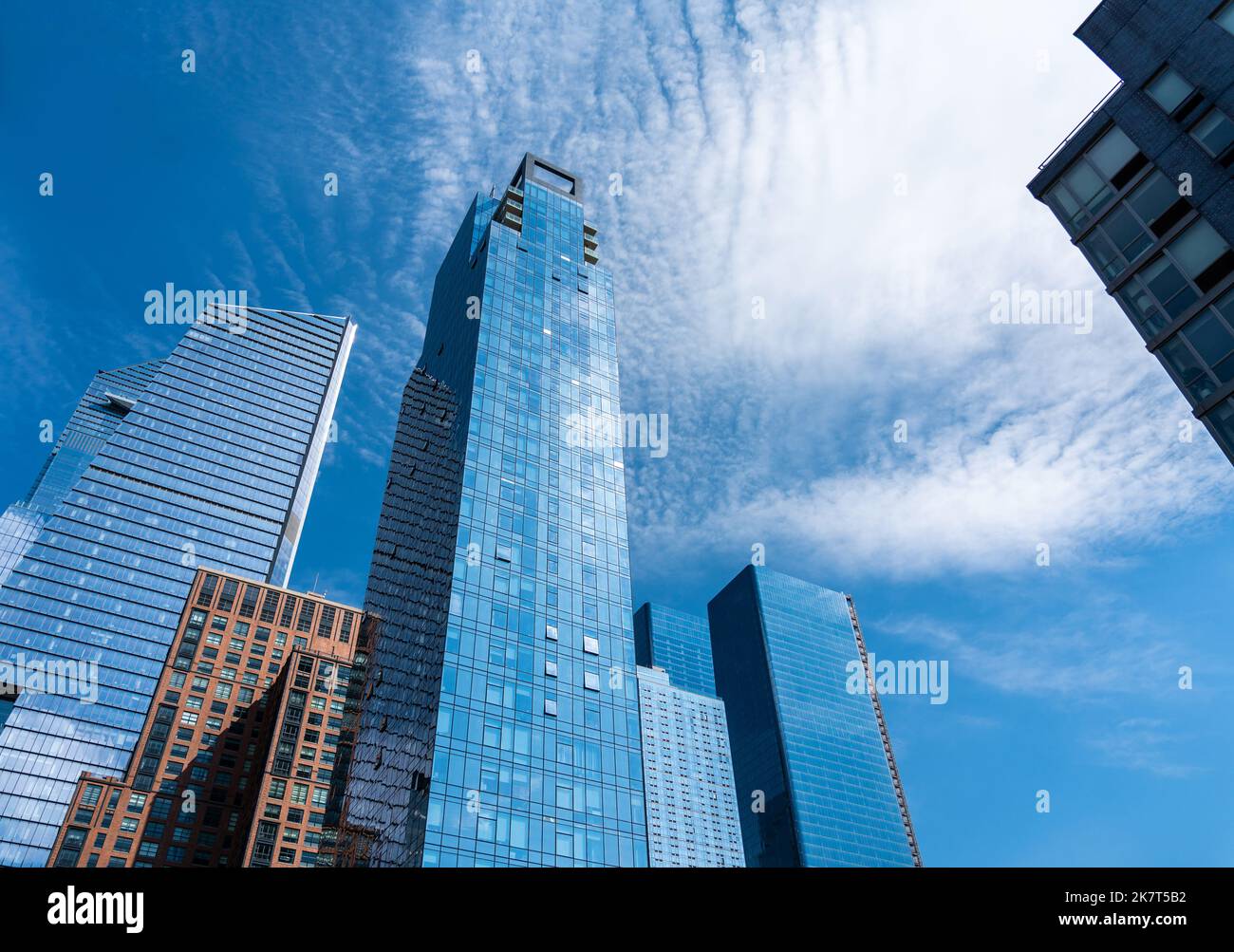 Cubetti di grattacieli in vetro e cemento che lasciano le loro cime nel cielo blu Foto Stock