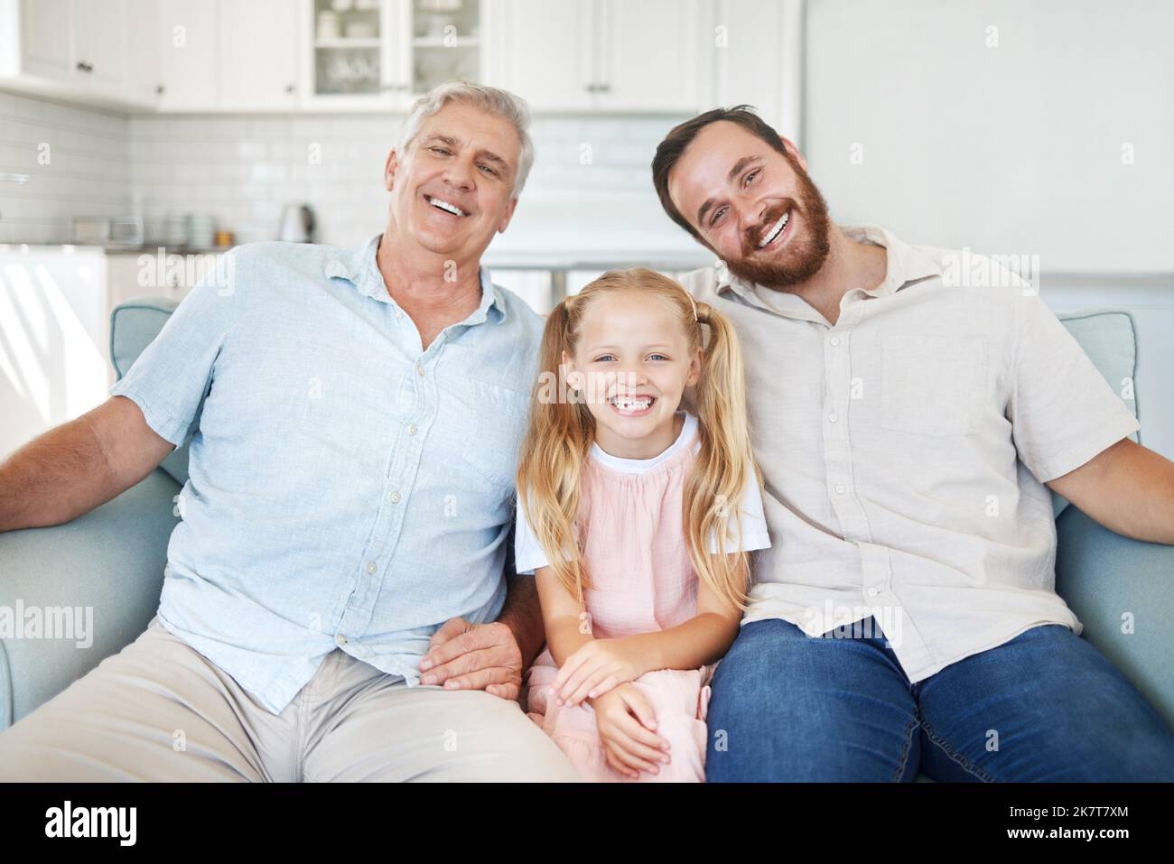 Ritratto in casa, ragazza con papà e nonno sul divano del soggiorno in Australia. Famiglia felice con il nonno anziano, sorridi insieme nel salotto e. Foto Stock