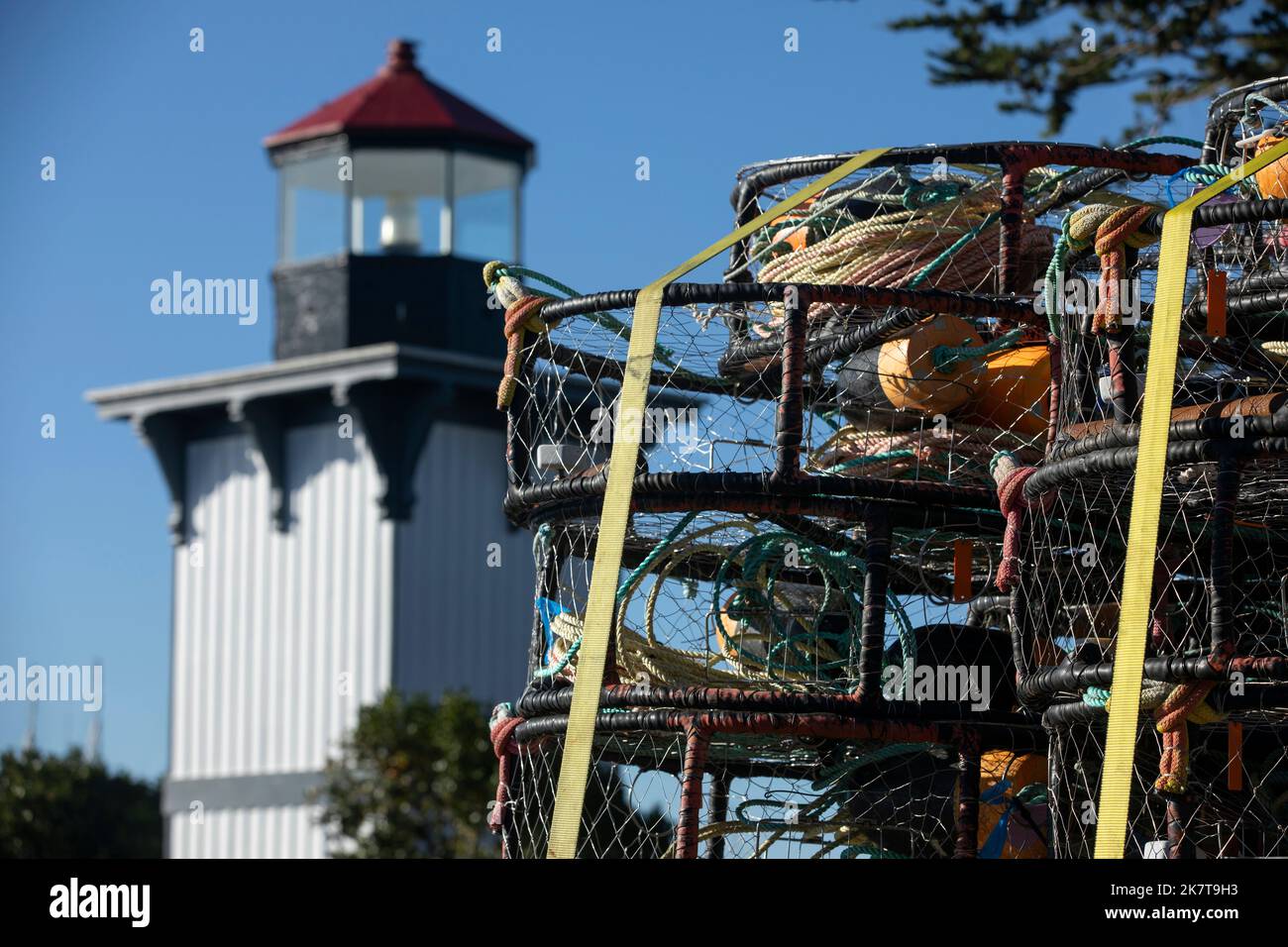 Vista diurna delle trappole di aragosta che incorniciano lo storico faro di Eureka, California, USA. Foto Stock