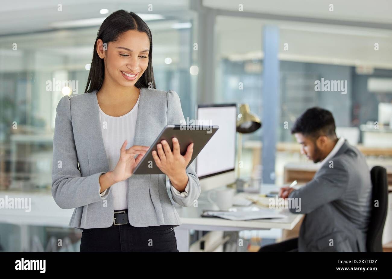 Realizzare grandi cose con piccoli dispositivi. una giovane donna d'affari che utilizza un tablet digitale in un ufficio moderno. Foto Stock