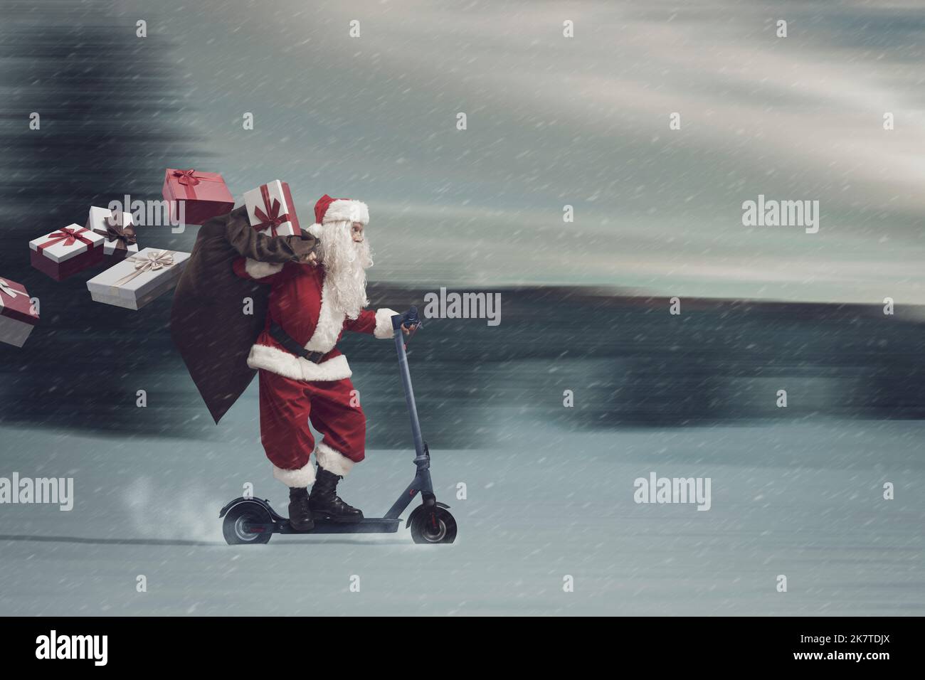 Babbo Natale contemporaneo in sella a uno scooter elettrico ecologico e con regali di Natale, paesaggio vinoso sullo sfondo Foto Stock