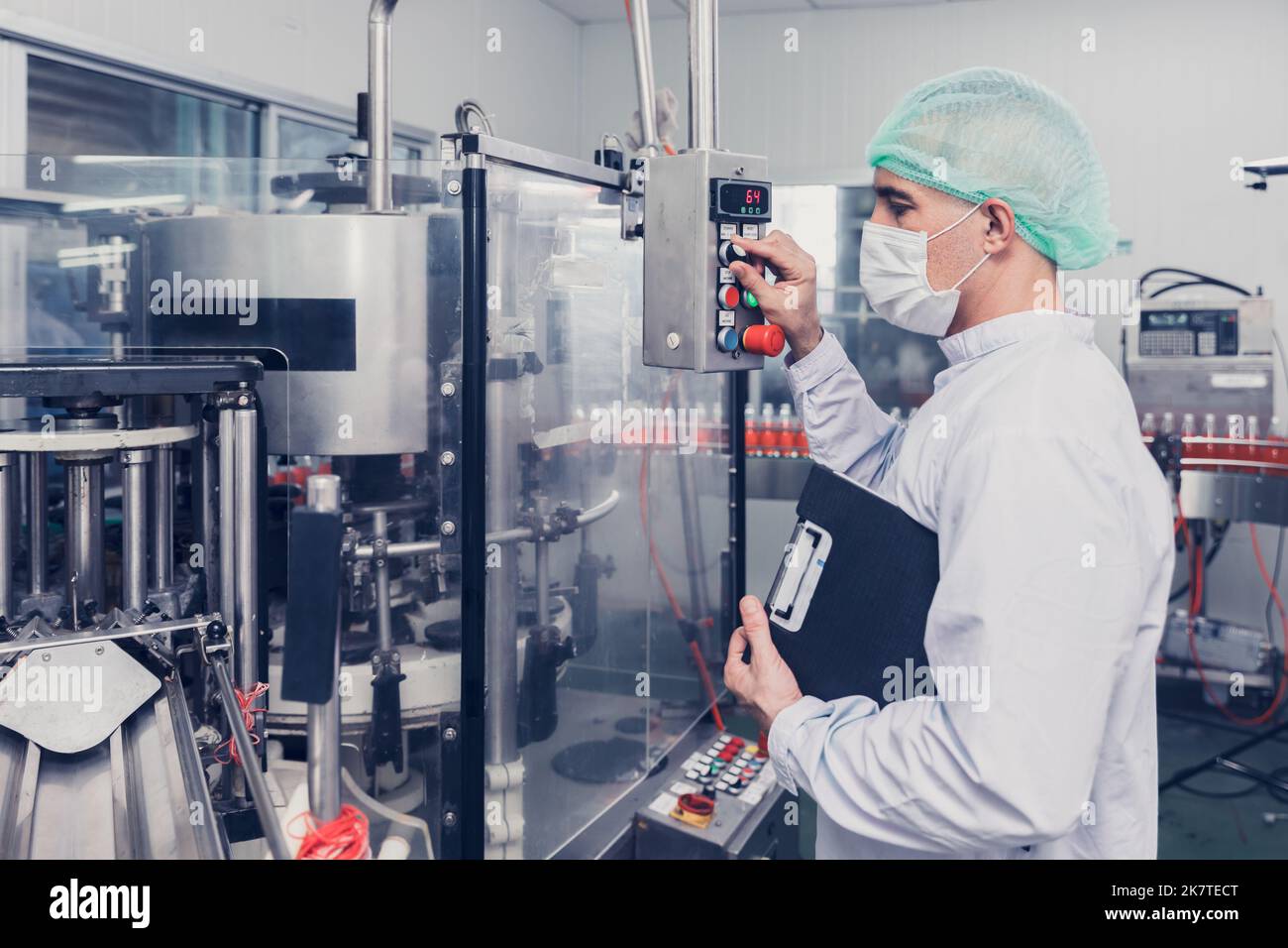 il personale di un ingegnere della fabbrica di alimenti e bevande lavora la macchina nella linea di produzione. industria dei prodotti per bevande. Foto Stock