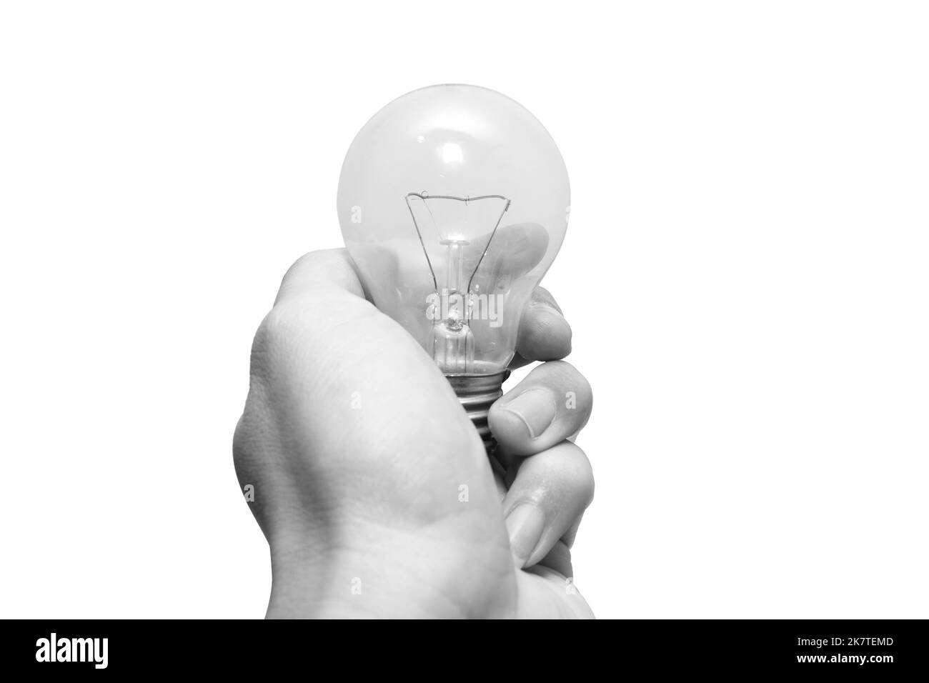 primo piano mano uomo bianco e nero che tiene vecchia lampadina di tungsteno isolato su sfondo bianco Foto Stock