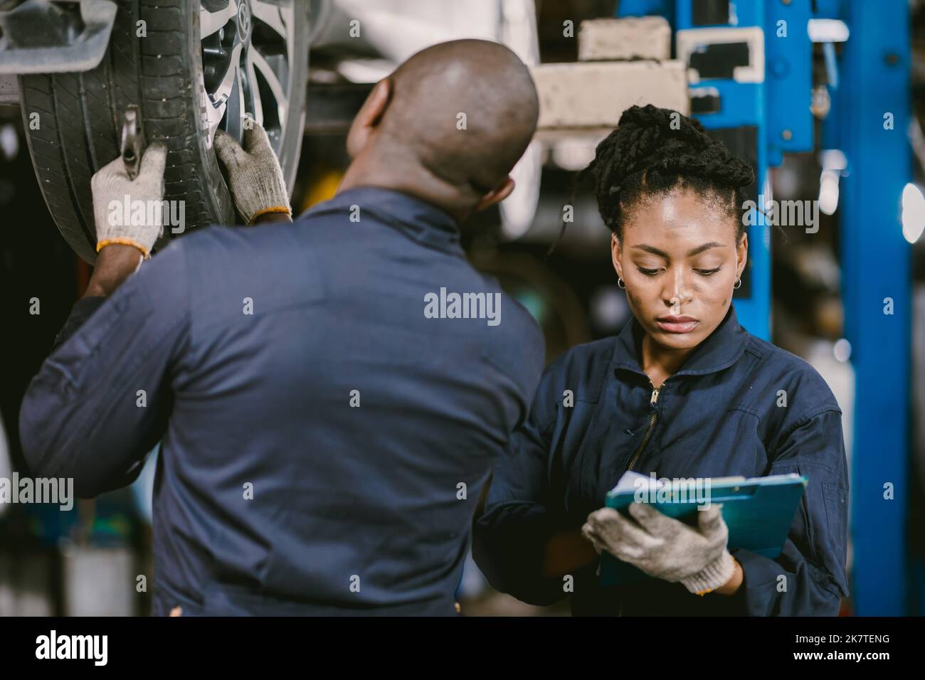 Meccanico team worker Black African lavorando insieme per la riparazione riparazione pneumatici vettura di controllo insieme in garage Foto Stock