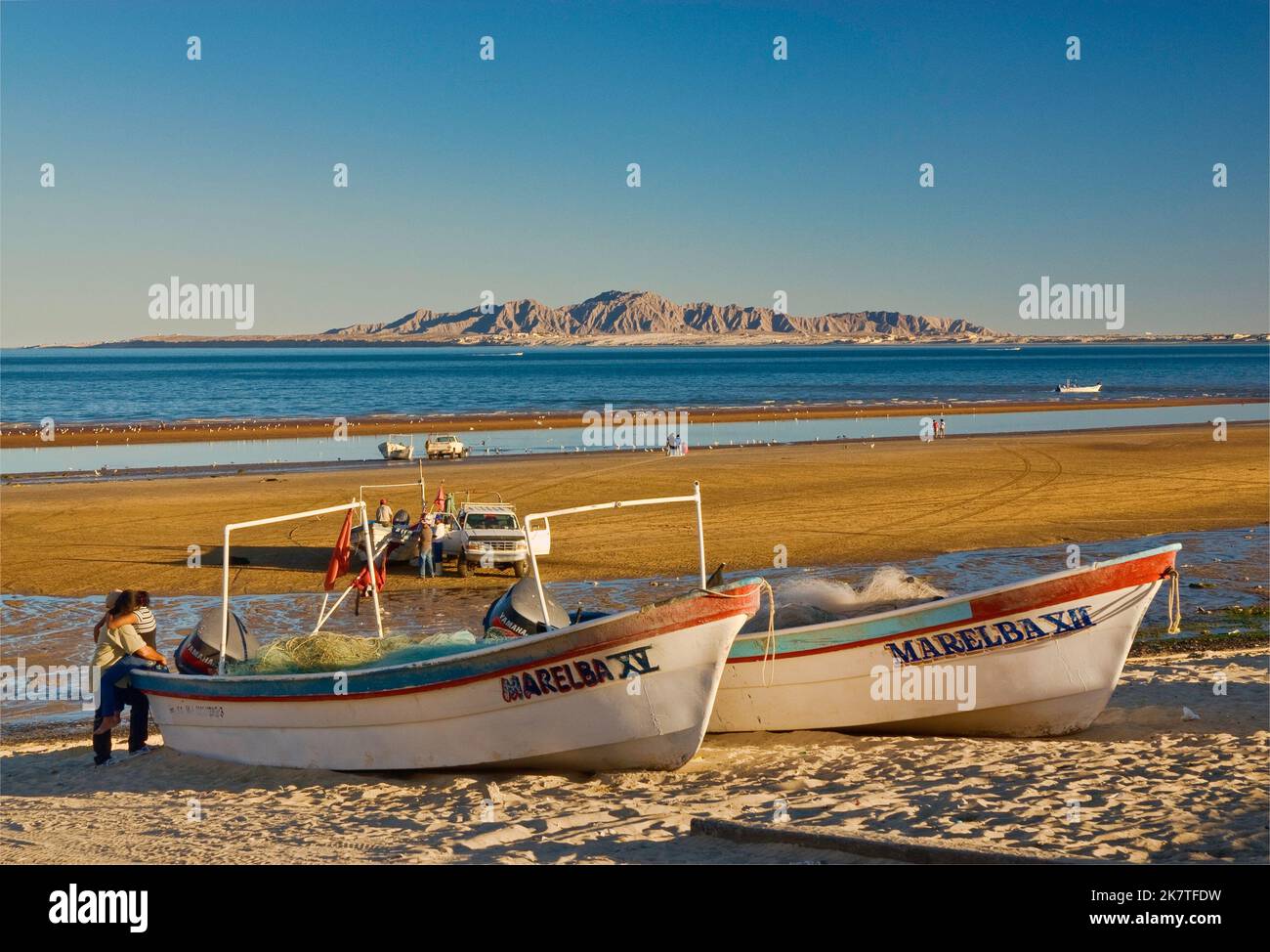 Barche e una coppia sulla spiaggia a Bahia de San Felipe, Baja California, Messico Foto Stock