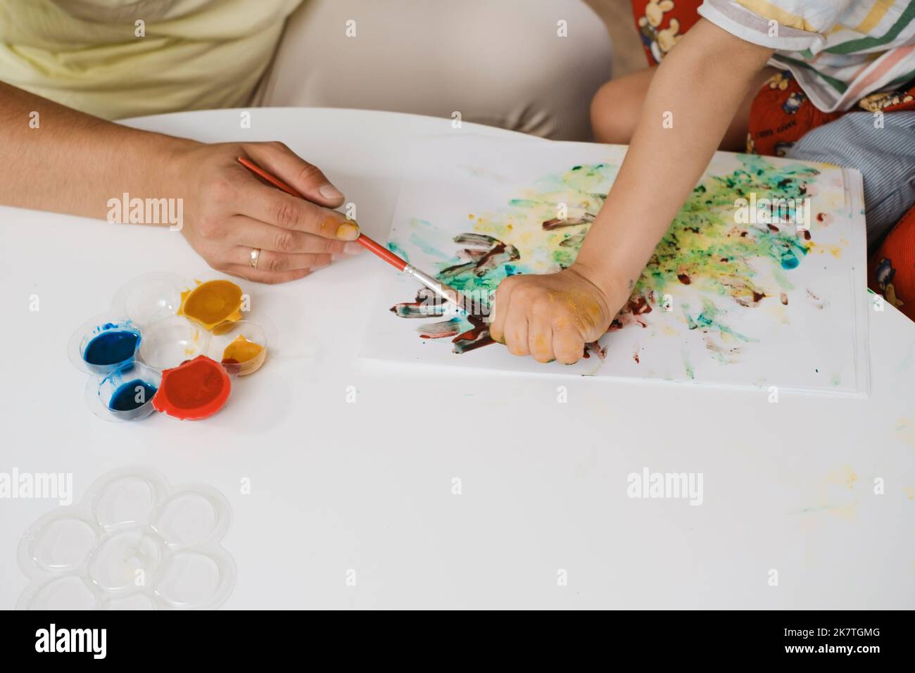 Bambino con paralisi cerebrale pittura con le dita e le mani ragazzo che ha problemi di salute sviluppare abilità motorie fini Educazione per i bambini con mentale Foto Stock