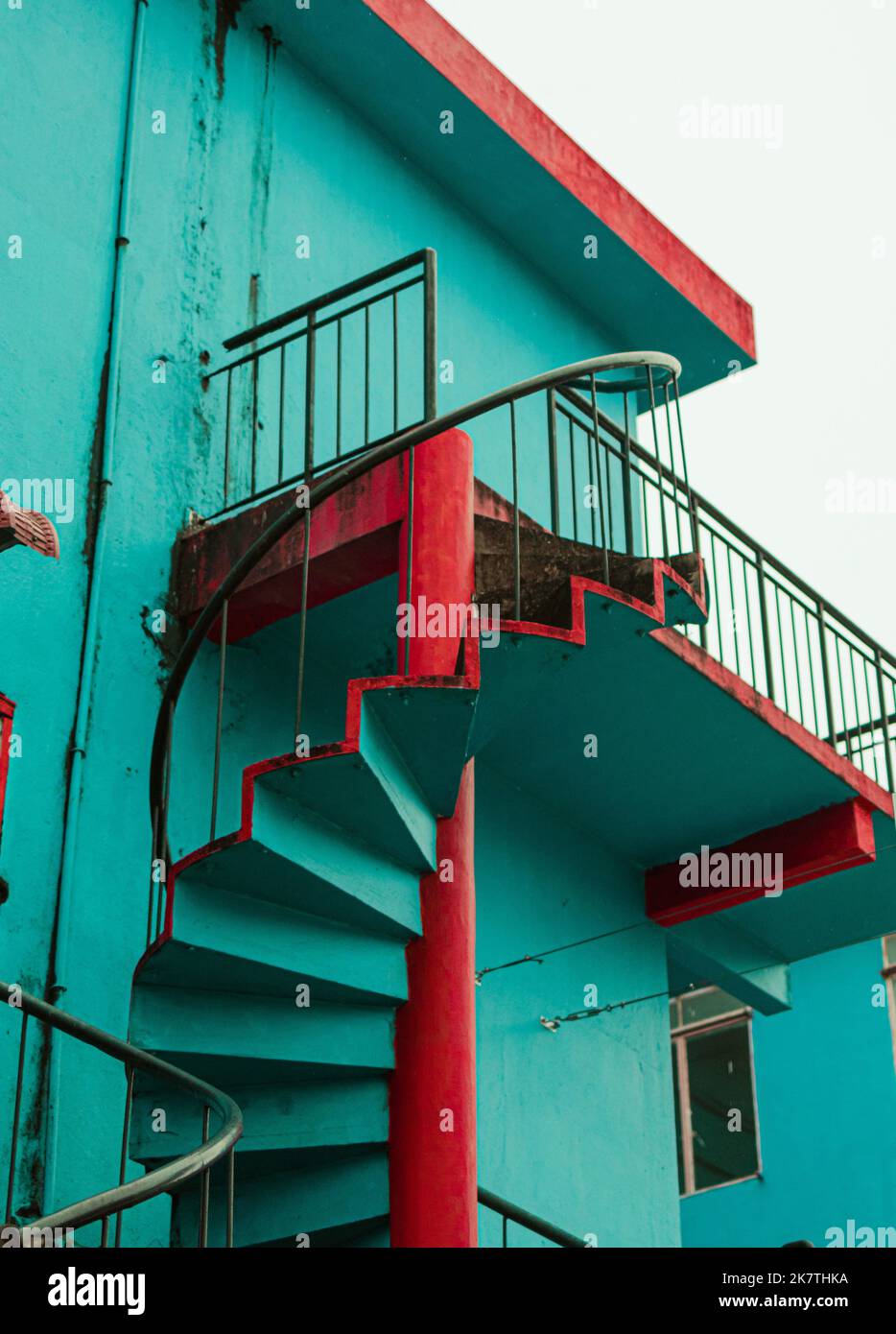 Bella scala a chiocciola sul lato di un edificio di colore verde e rosso a Perlis, Malesia. Foto Stock