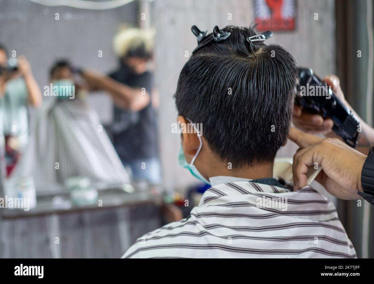 Barbiere maschile utilizzando la macchina per tagliare i capelli del  ragazzo adolescente al salone Foto stock - Alamy