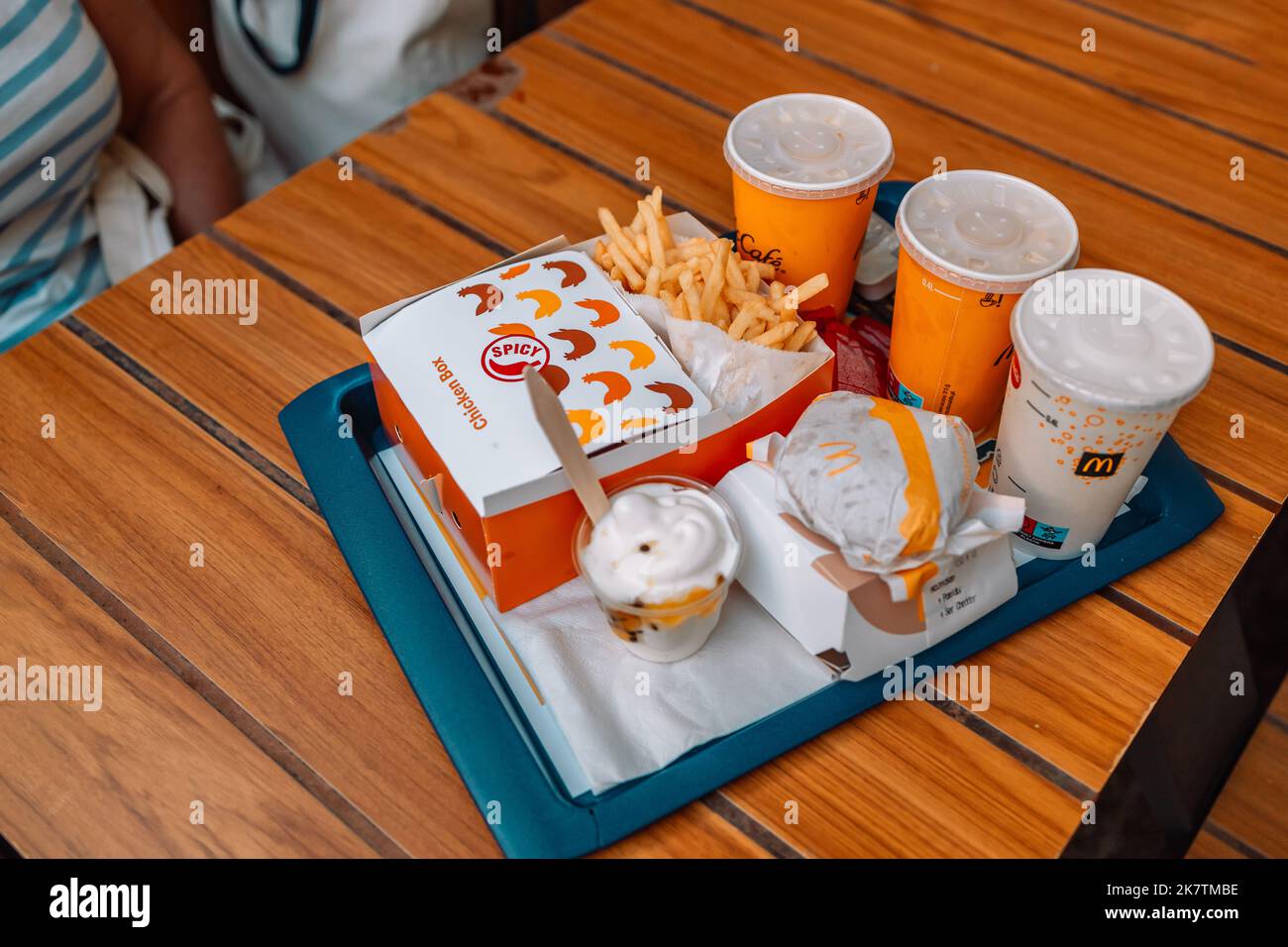 Cracovia, Polonia - 25 agosto 2022: Il cibo di McDonald sul tavolo sullo sfondo verde del cespuglio. Grande menu Mac. Borsa McDonald's accanto al bicchiere di cola, fritto Foto Stock