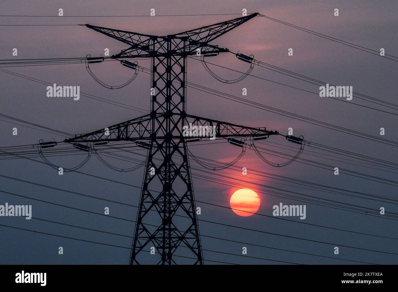 Linea elettrica ad alta tensione, torre di trasmissione al tramonto Foto Stock