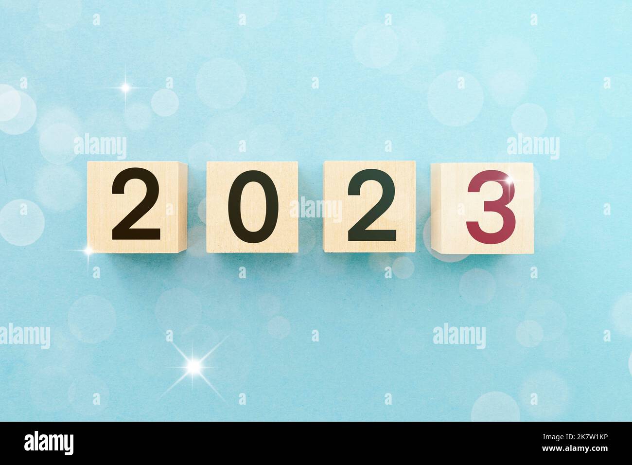 Foto di Capodanno 2023. Cubi di legno su sfondo blu con bokeh con numeri 2023. Immagine di concetto di affari con tema di natale. Foto Stock