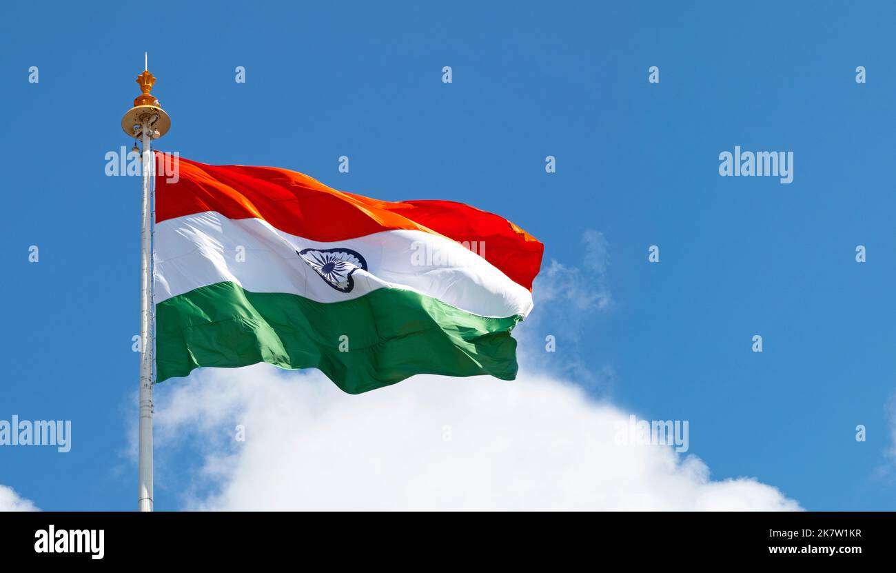 Grande bandiera indiana o bandiera dell'India che sventola di fronte al cielo blu durante il giorno di sole, spazio per il testo Foto Stock