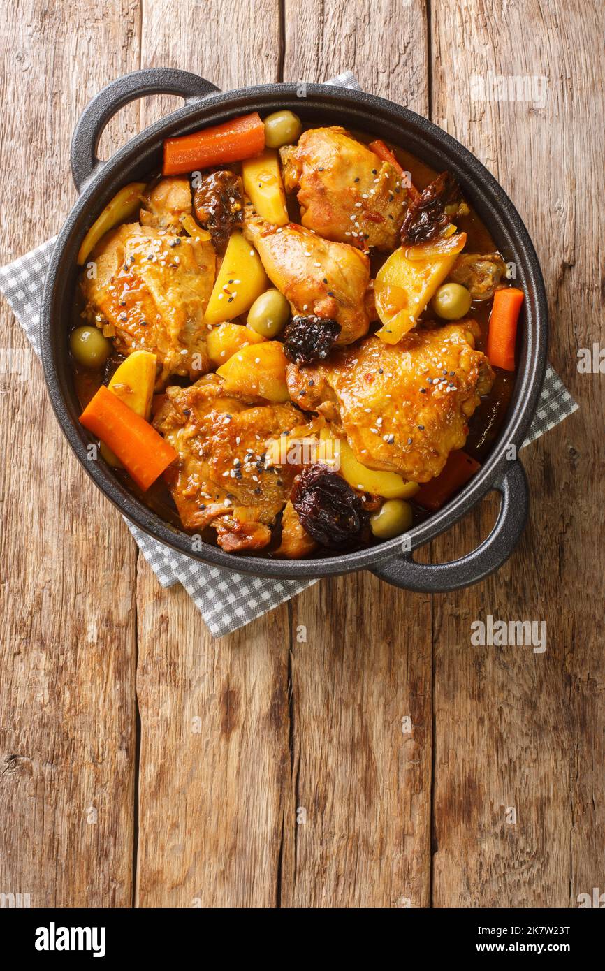 Gallo en chicha pollo Salvadoran brasato in fichi e piccante ananas chicha con verdure primo piano sulla padella sul tavolo di legno. Verticale in alto vi Foto Stock