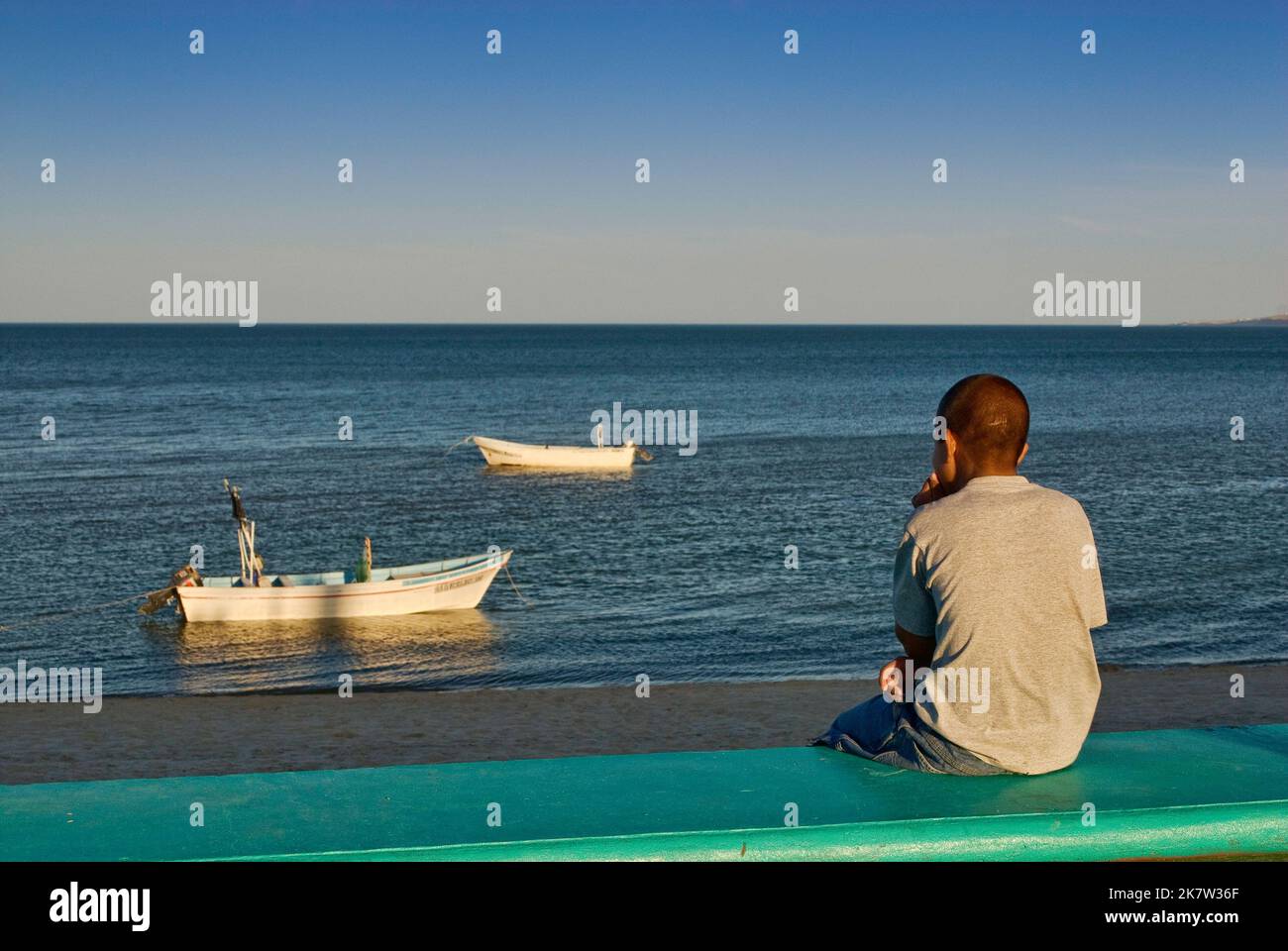 Ragazzo che guarda le barche a Bahia de San Felipe, a San Felipe, Baja California, Messico Foto Stock