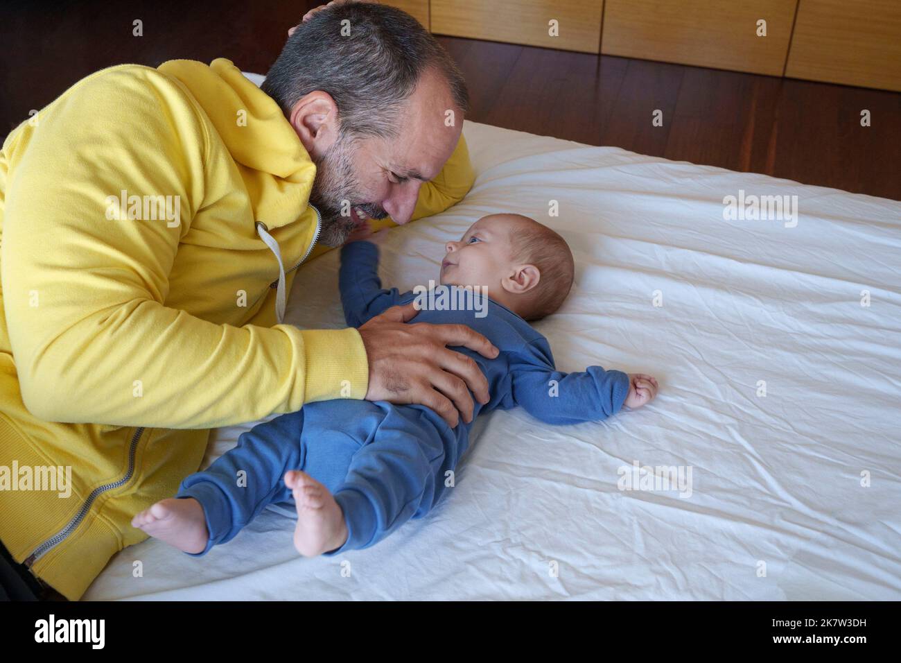 Il bambino e il padre si guardano e sorridono felicemente Foto Stock
