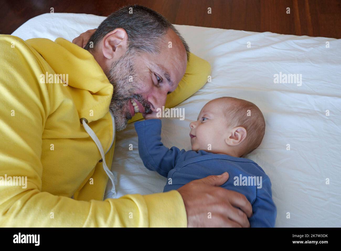 Il bambino e il padre si guardano e sorridono felicemente Foto Stock