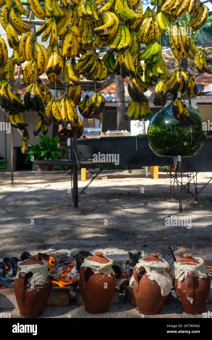 Banane appese cucinate a fuoco basso per preparare un piatto vegetariano, in un festival alimentare a Estoril, Lisbona, Portogallo. Foto Stock