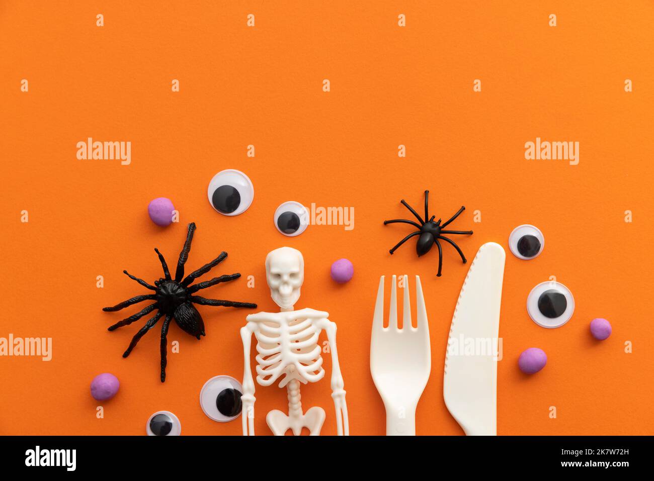 Carino sfondo festa di Halloween per bambini con posate, ragni scheletro e eyeballs Foto Stock