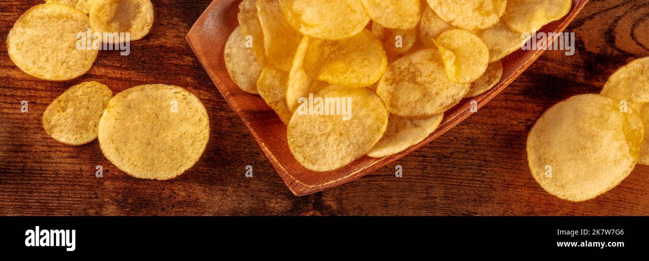 Patatine fritte o crocchette di patate, uno spuntino salato su uno sfondo di legno, una testata panoramica, shot superiore Foto Stock
