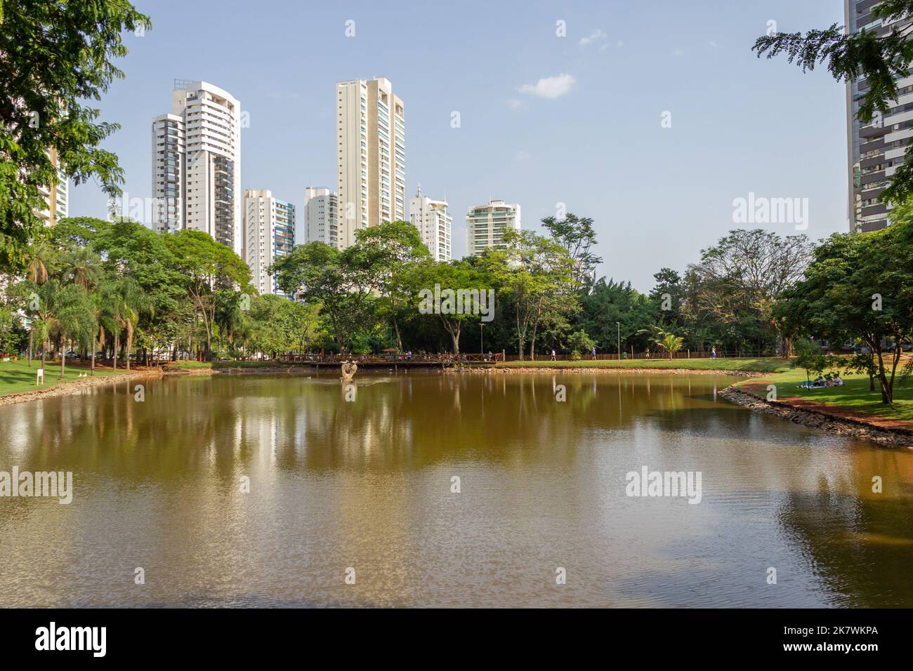 Goiânia, Goias, Brasile – 18 ottobre 2022: Un angolo del Parco Flamboyant, che mostra il lago, gli alberi, gli edifici e il cielo blu sullo sfondo. Foto Stock