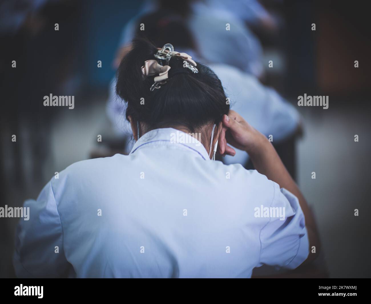 Studenti che leggono i fogli di risposta degli esami Esercizi in classe con mal di testa e stress Foto Stock