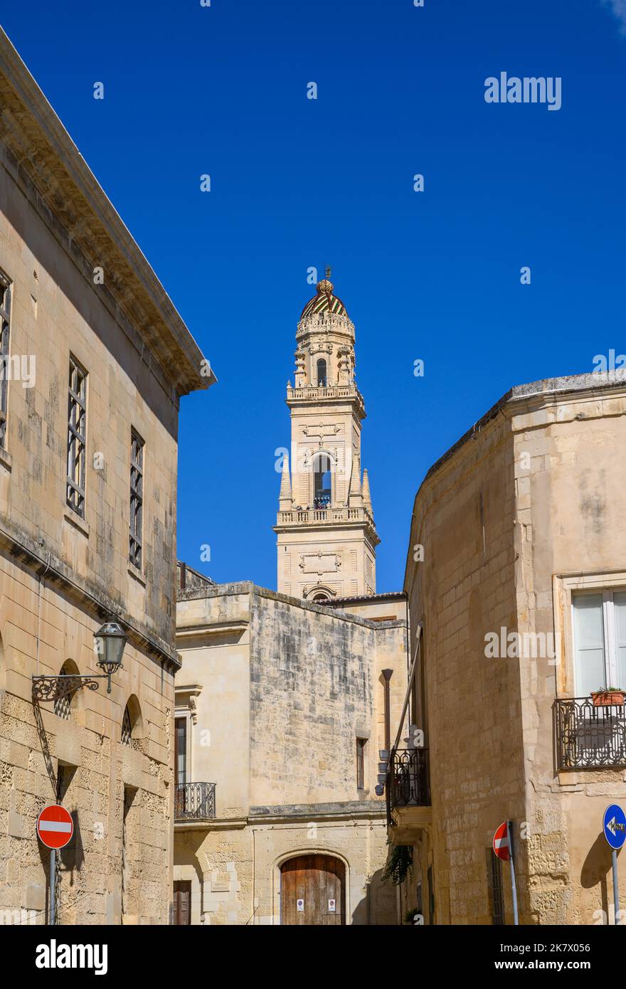 Il campanile della Cattedrale di Lecce visibile dietro e tra gli edifici in pietra del centro storico. Puglia, Italia. Foto Stock