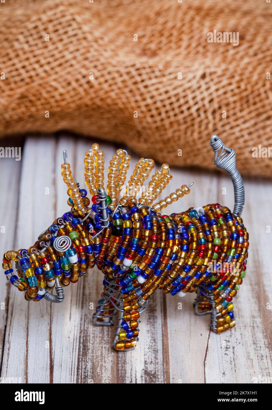 Colorato sudafricano con perline artigianato di warthog su superficie rustica con tela di tela di tela Foto Stock