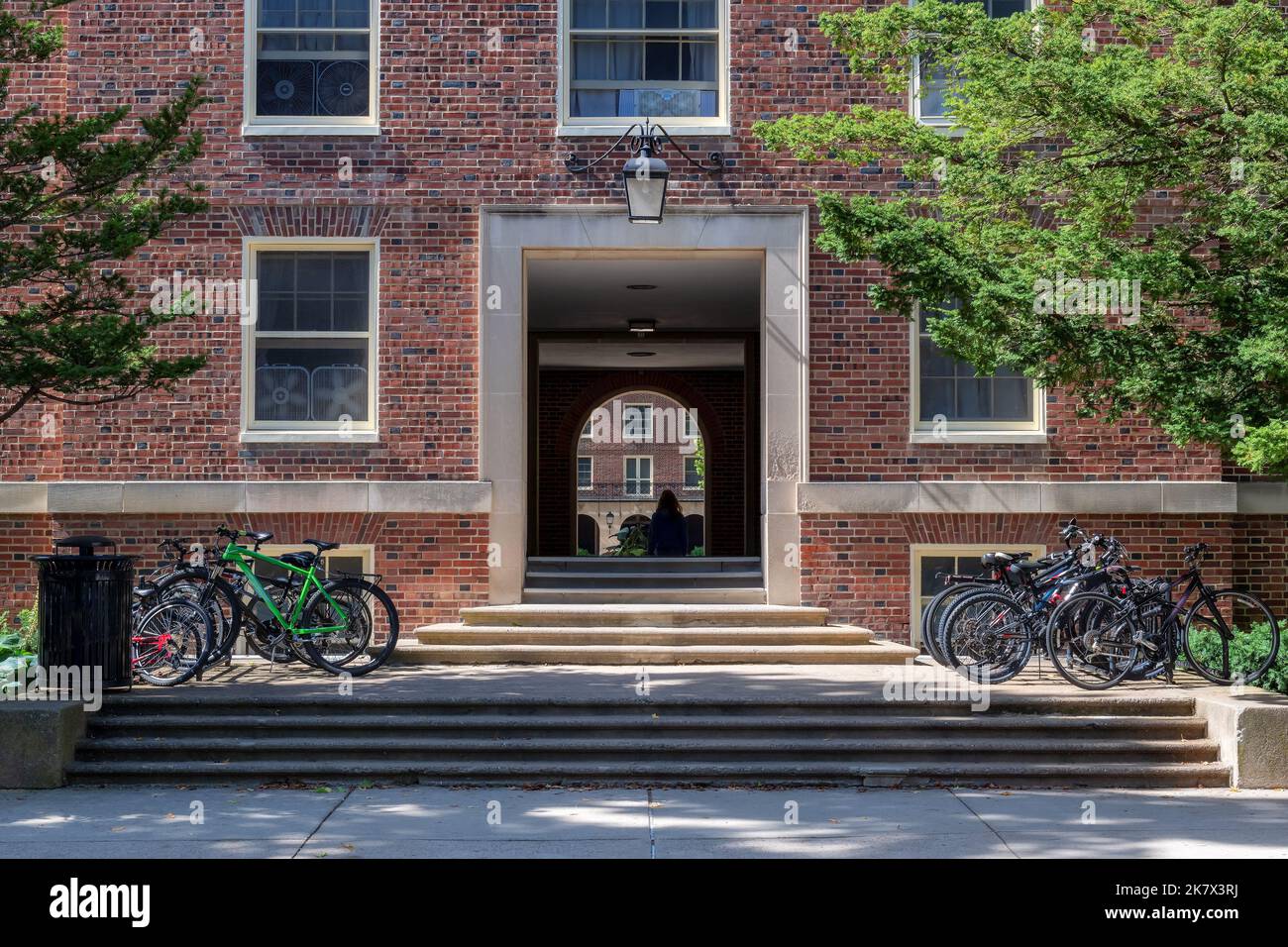 Strada vuota con vecchie case in mattoni e arco e biciclette alla Penn state University in primavera giorno di sole, state College, Pennsylvania. Foto Stock