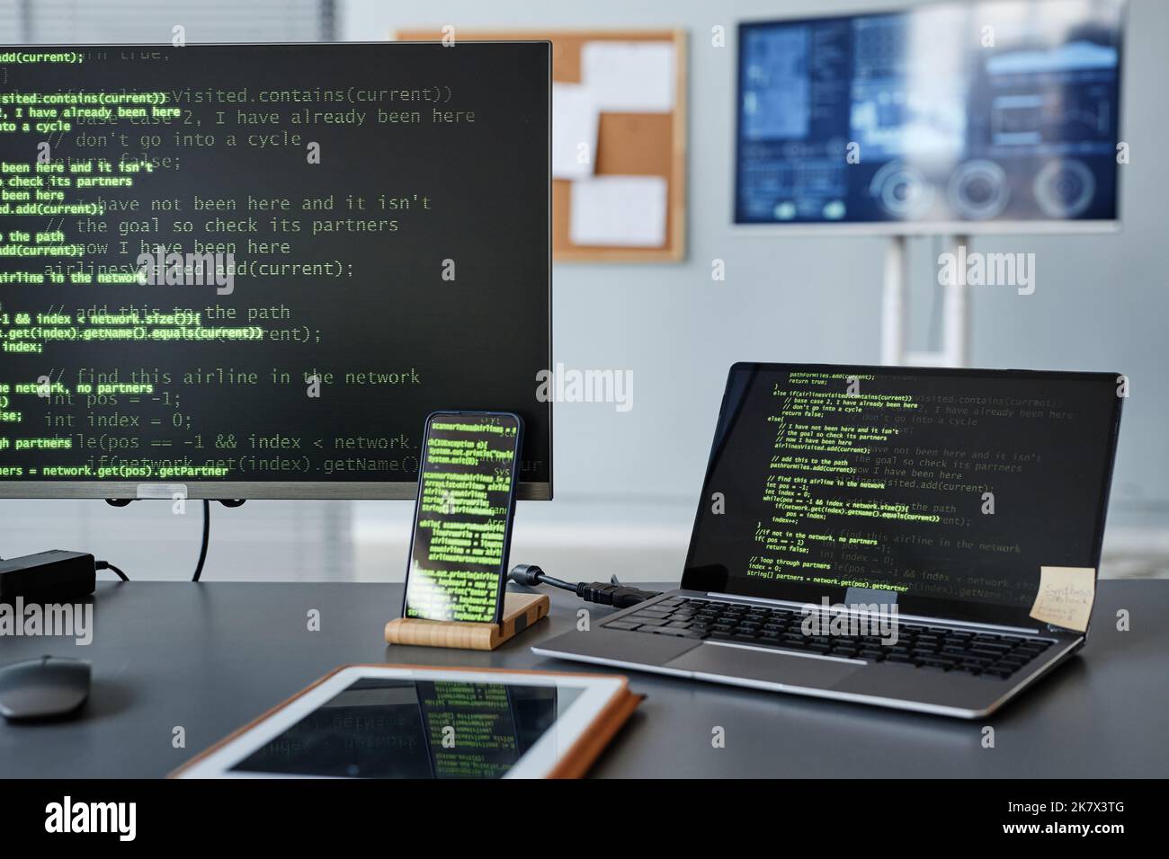 Immagine di sfondo degli schermi dei computer con linee di codice verdi sul posto di lavoro dei programmatori Foto Stock