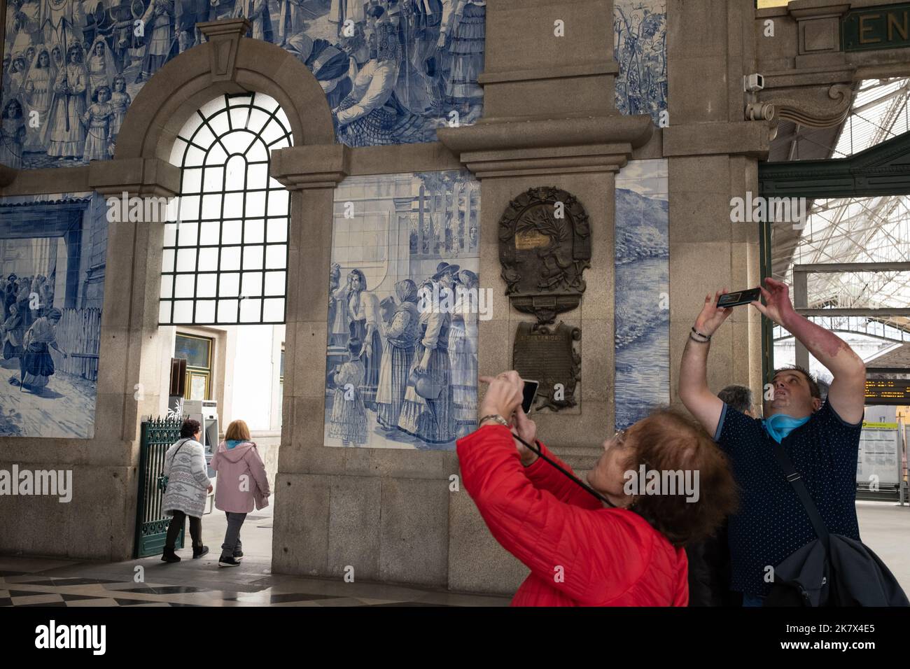 Turisti alla stazione ferroviaria di Sao Bento fotografando i murales piastrelle blu, a Porto, Portogallo, 16 ottobre 2022. Foto Stock