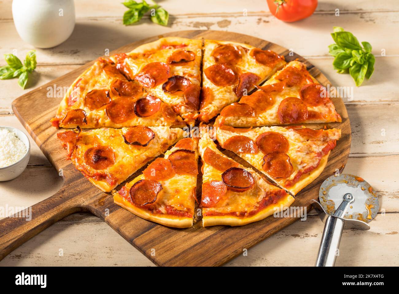 Pizza pepperoni fatta in casa a fette con pomodoro e salsa di basilico Foto Stock