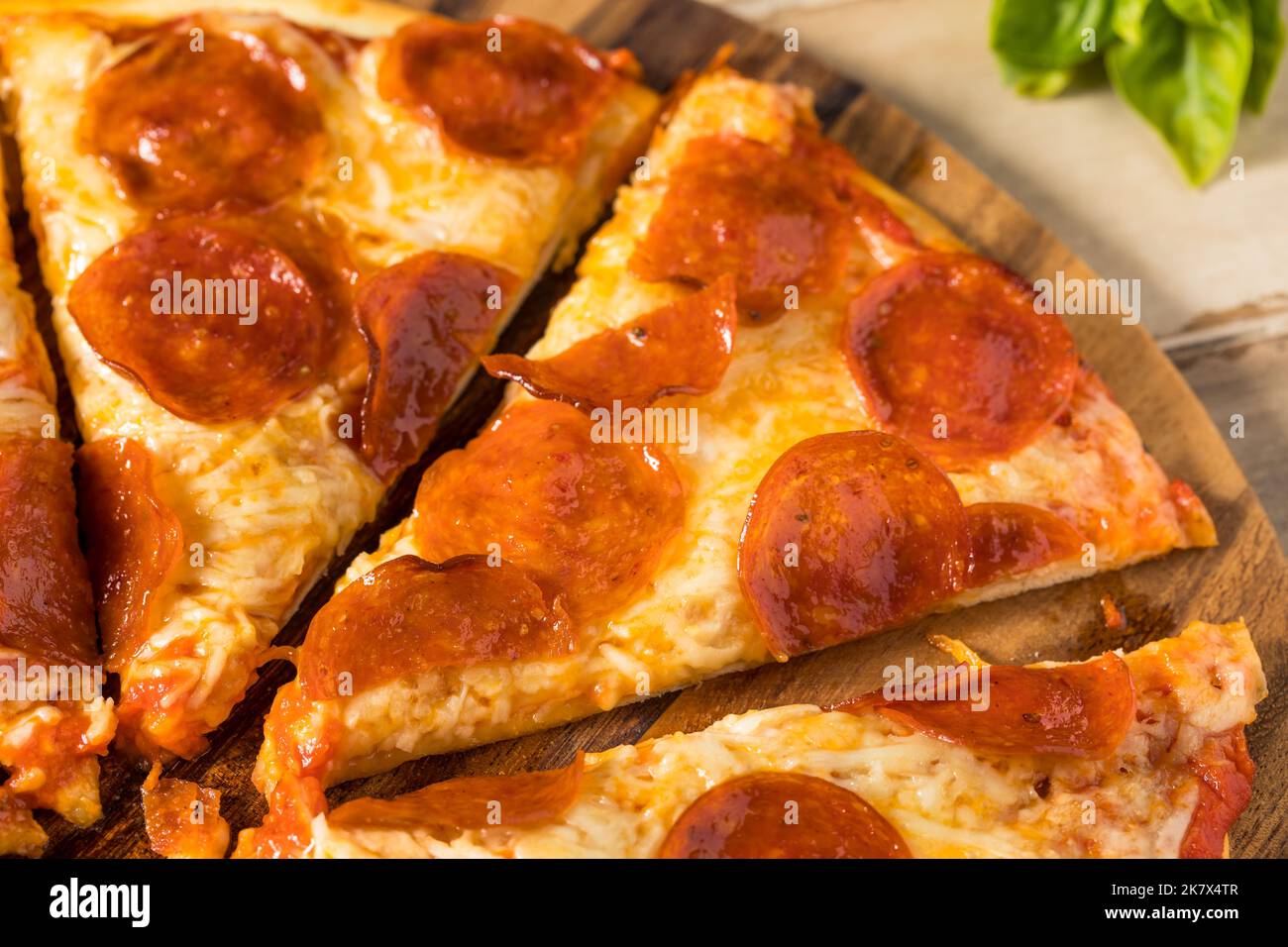 Pizza pepperoni fatta in casa a fette con pomodoro e salsa di basilico Foto Stock