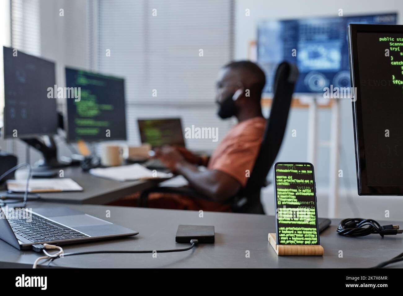 Immagine di sfondo delle righe di codice verde sullo schermo dello smartphone nell'ufficio di sviluppo software, spazio copia Foto Stock