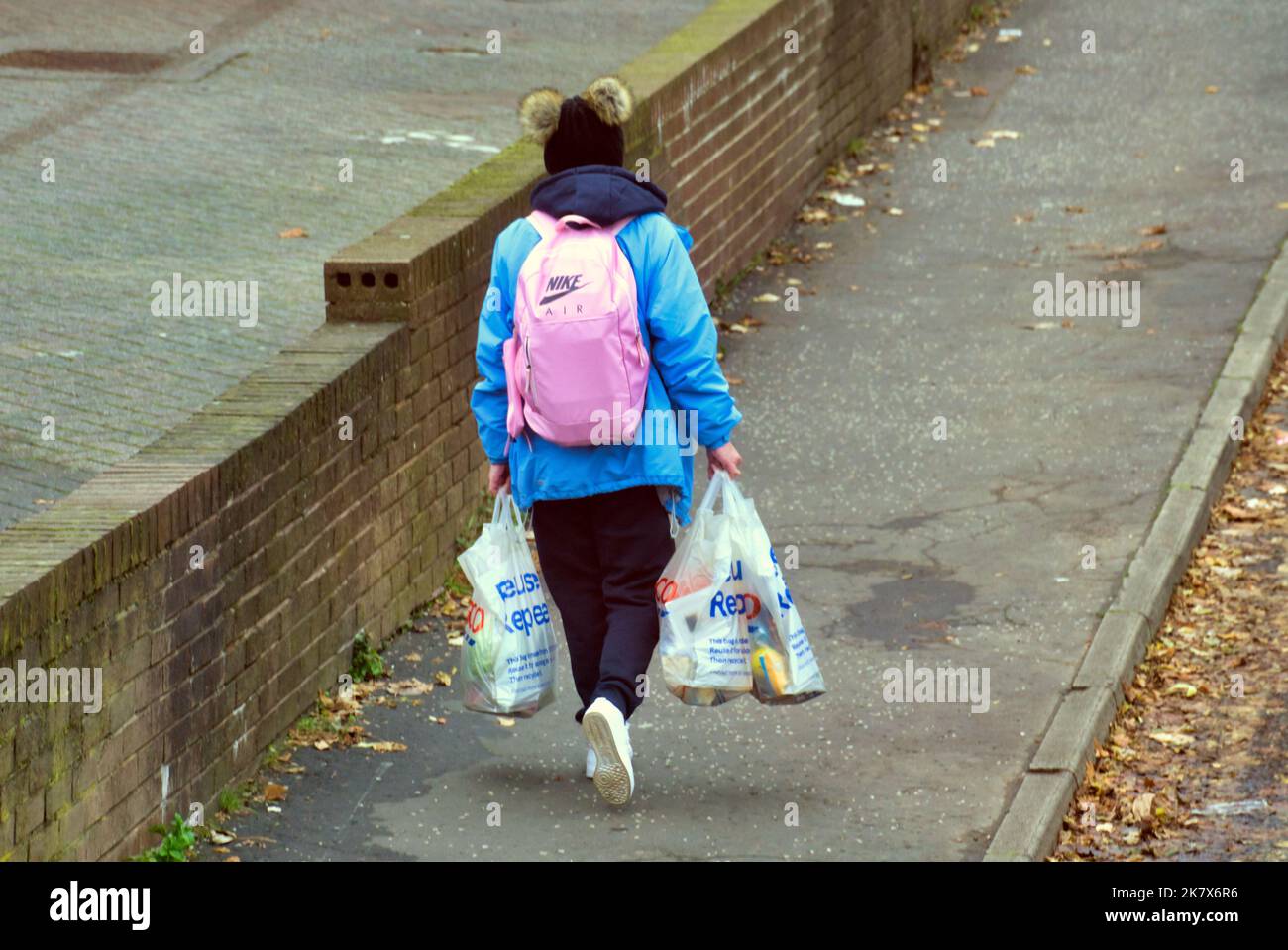 donne povere senza auto di ritorno a casa con shopping in borse e zaino Foto Stock