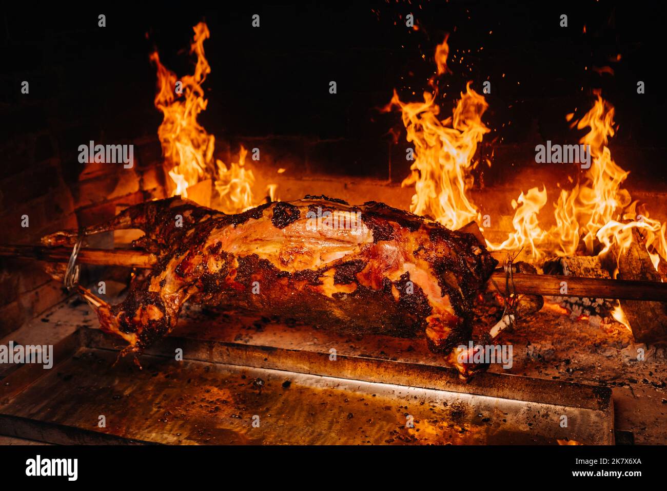 L'agnello è cotto interamente su uno spiedo sul fuoco. Cucina Foto Stock