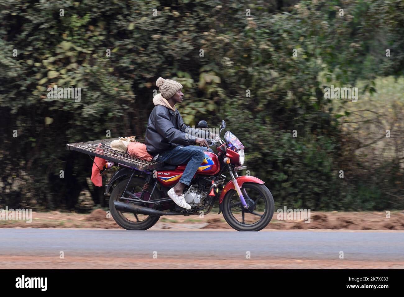 Un taxi motociclistico, conosciuto come Boda boda, in Africa orientale, che trasporta una struttura del letto. I Boda Boda sono una parte importante della rete di trasporto, essendo utilizzati per la prima volta Foto Stock