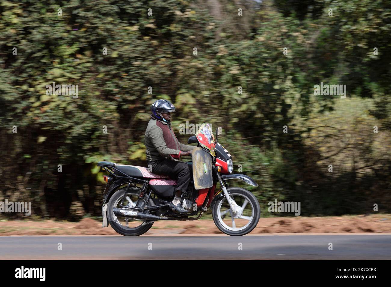 Un taxi motociclistico, conosciuto come Boda boda, in Africa orientale, che trasporta una struttura del letto. I Boda Boda sono una parte importante della rete di trasporto, essendo utilizzati per la prima volta Foto Stock