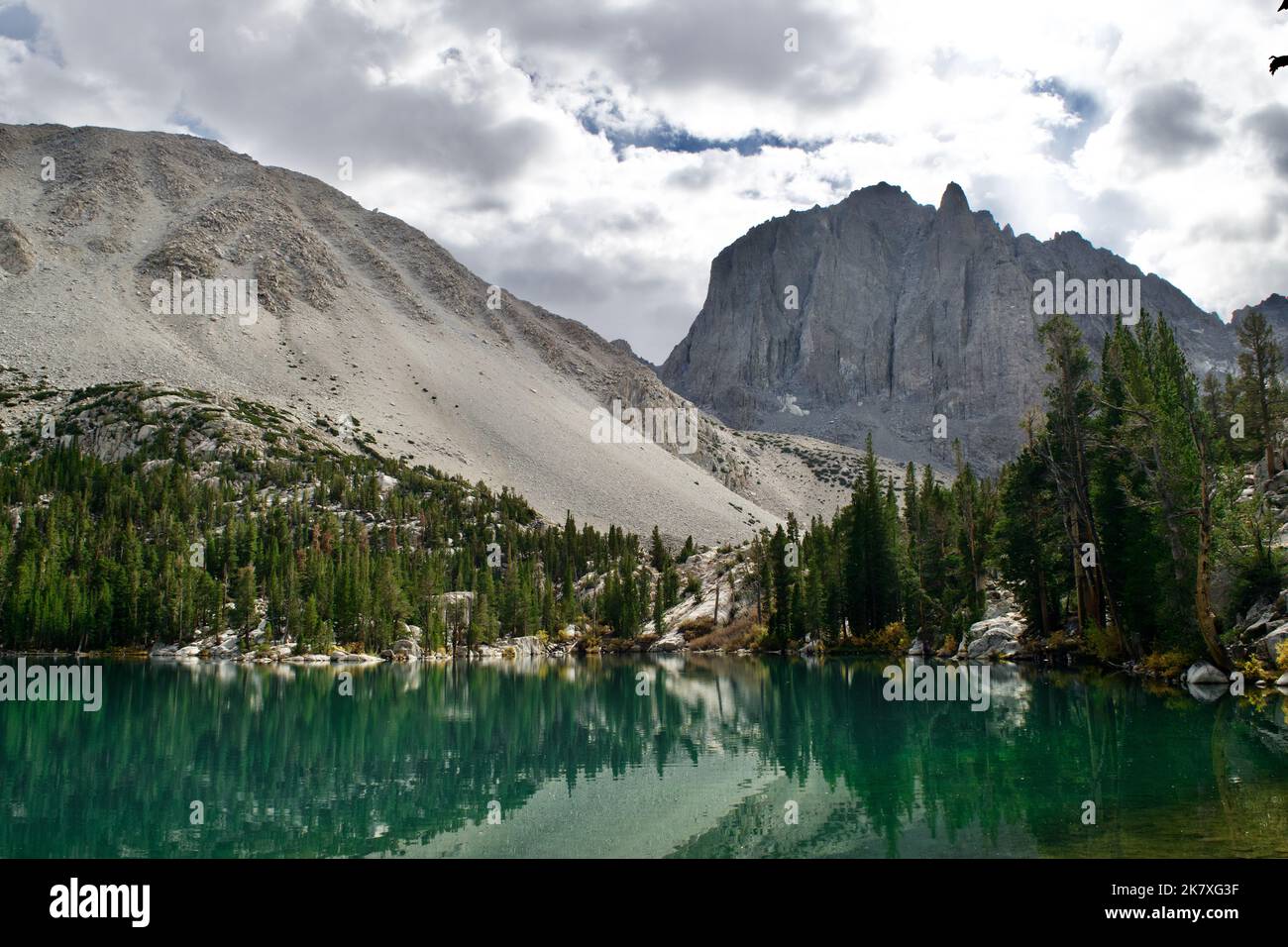 Ampia vista sulle montagne dietro un lago di montagna turchese. Foto Stock