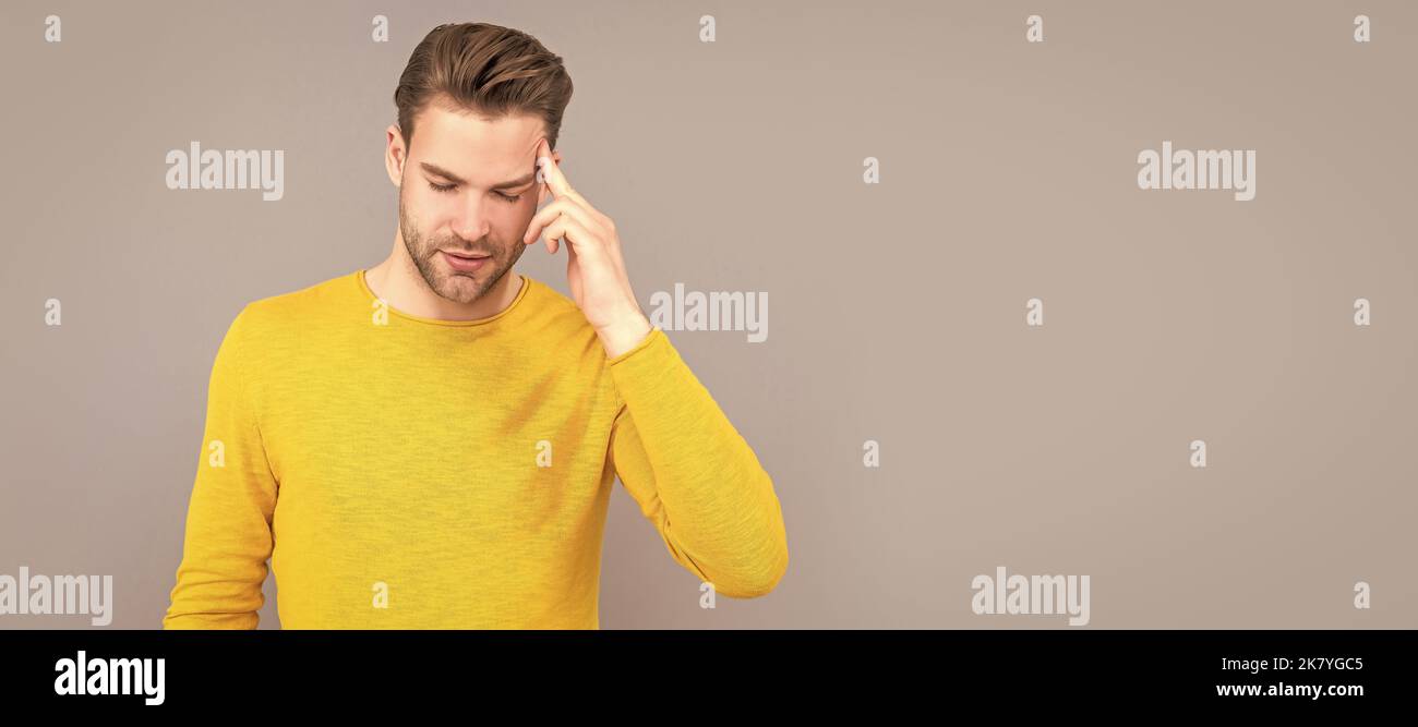 L'uomo malato infelice soffre di emicrania attacco sfondo grigio, mal di testa. Ritratto del volto uomo, banner con spazio per la copia. Foto Stock