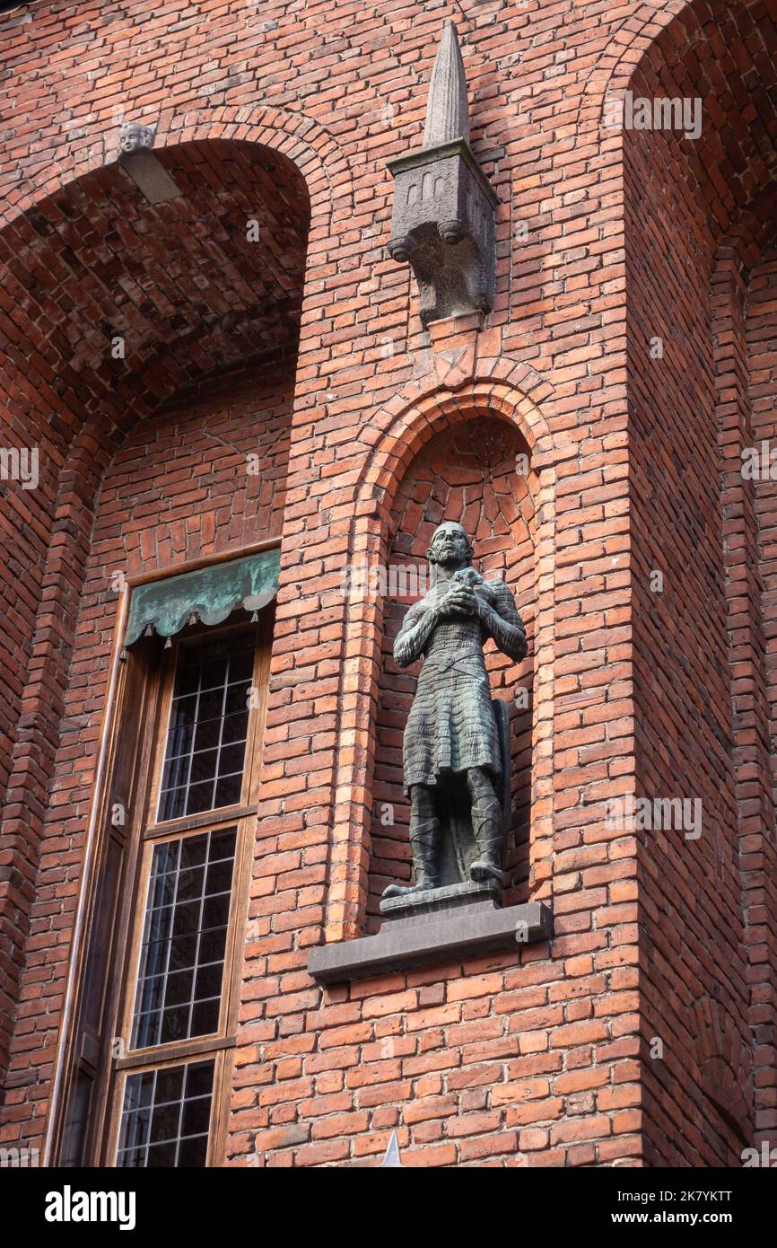 Svezia, Stoccolma - 16 luglio 2022: Municipio o Stadshuset. La statua di bronzo dell'uomo anziano si erge nella prima nicchia da est sulla facciata sud di mattoni del cortyar Foto Stock