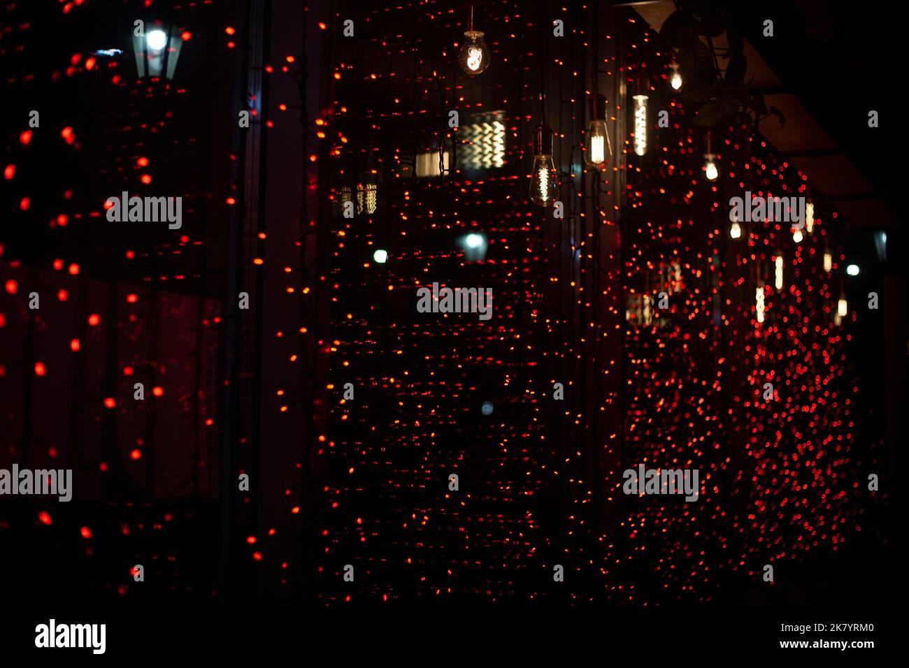 Garland sulla finestra. Luci rosse. Texture di piccole lampade. Dettagli della finestra. Sorgente luminosa. Foto Stock