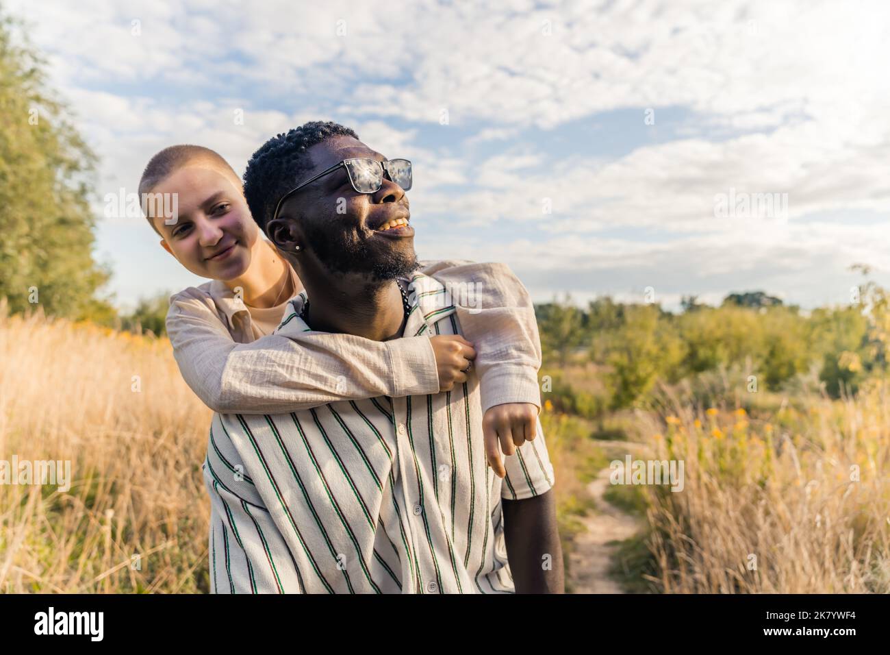 Naturalmente bello ritratto all'aperto di due amici vicini etnicamente diversi o amanti che trascorrono il loro tempo in campagna. Viaggi e tempo libero. Foto di alta qualità Foto Stock