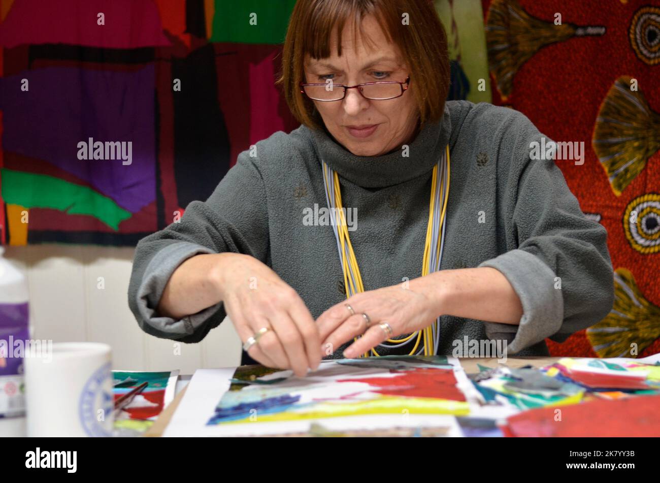 donna pensionato maturo pittura e la creazione di collage di carta Foto Stock