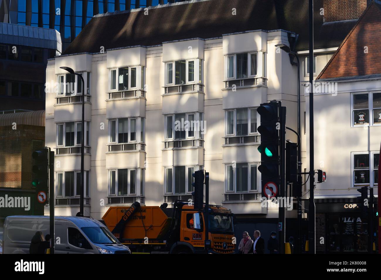 LONDRA - 2 novembre 2020: Luci e ombre nel tardo pomeriggio sull'edificio degli uffici di Whitechapel. Semafori e semafori in primo piano Foto Stock
